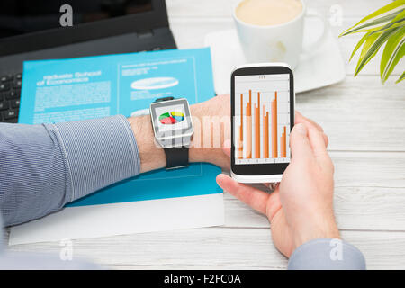 Unternehmer nutzt smart Watch und Telefon. Smartwatch Konzept. Stockfoto