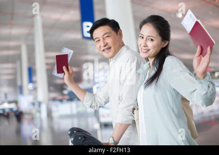 Älteres Paar zu Fuß in Flughafen mit Koffer Stockfoto