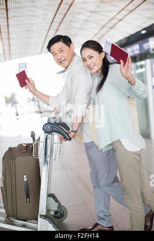 Älteres Paar zu Fuß in Flughafen mit Koffer Stockfoto