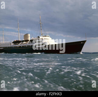 AJAXNETPHOTO. 1977. SOLENT, ENGLAND. -KÖNIGLICHE YACHT - DIE ROYAL YACHT BRITANNIA WEG UNTER GEWITTERHIMMEL KÖPFE FÜR COWES, ISLE OF WIGHT, UM ANKER AUS DEM HAFEN FÜR DIE COWES WOCHE SEGELN REGATTA FOTO: JONATHAN EASTLAND/AJAX REF: 703991 Stockfoto