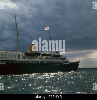 AJAXNETPHOTO. 1977. SOLENT, ENGLAND. -KÖNIGLICHE YACHT - DIE ROYAL YACHT BRITANNIA WEG UNTER GEWITTERHIMMEL KÖPFE FÜR COWES, ISLE OF WIGHT, UM ANKER AUS DEM HAFEN FÜR DIE COWES WOCHE SEGELN REGATTA FOTO: JONATHAN EASTLAND/AJAX REF: 703994 Stockfoto