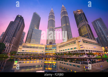 Die Petronas Towers angesehen vom KLCC Park in der Dämmerung. Stockfoto