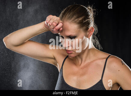 Nachdenklich sportliche Frau mit der Hand auf der Stirn Stockfoto