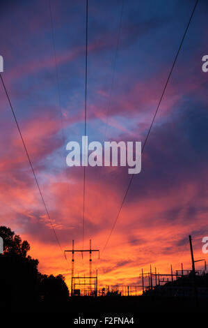 Macht Übertragungsleitungen erstrecken sich von einer elektrischen Schaltanlage unter einem lebendigen Sonnenuntergang Himmel in Snellville (Metro Atlanta), Georgien. Stockfoto