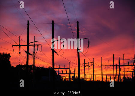 Eine Umspannstation Silhouette gegen eine lebendige Sonnenuntergang Himmel. Stockfoto