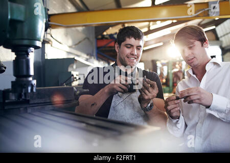 Mechaniker und Kunden untersuchen Teile im Auto-Werkstatt Stockfoto