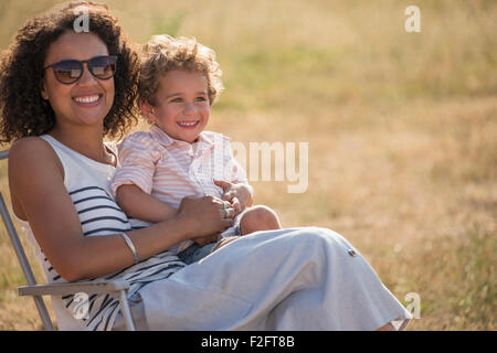 Porträt, Lächeln, Mutter und Sohn im sonnigen Feld Stockfoto
