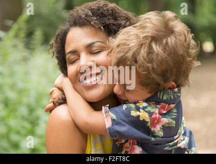 Liebevolle Mutter und Sohn umarmt mit geschlossenen Augen hautnah Stockfoto