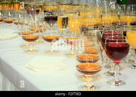 viele Weingläser mit alkoholischen Getränken auf dem Tisch Stockfoto