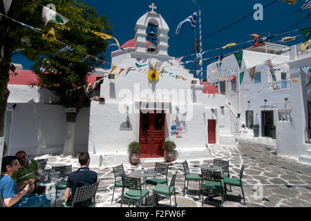 Männer im Café im Freien genießen Sonne vor Agia Kyriaki Kirche, Mykonos-Stadt, Kykladen, Griechenland Stockfoto