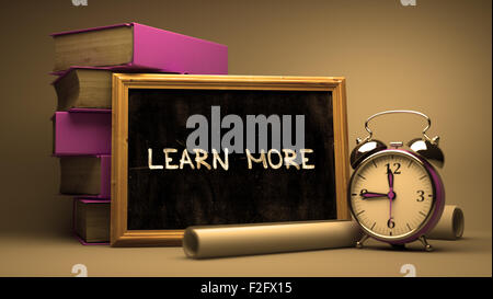 Weitere Informationen - Tafel mit handgezeichneten Text, Stapel von Büchern, Wecker und Papierrollen auf der Hintergrund jedoch unscharf. Getönten Image. Stockfoto