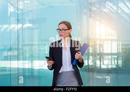 Geschäftsfrau, die mit einem smart-phone Stockfoto