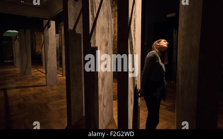 London, UK. 18. September 2015. Eine Frau untersucht die Ogham-Wand von Grafton Architects. Irische und britische Menhire gleichend, tragen diese 23 "Flossen" eine antike Alphabet, das tief in der Geschichte der irischen Celtic entstanden. Das Victoria und Albert Museum feiert das London Design Festival läuft von 19 – 27 September, zeigt eine Sammlung von konzeptionellen Installation Kunstwerke. Bildnachweis: Paul Davey/Alamy Live-Nachrichten Stockfoto