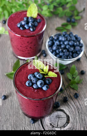 Brille von Blueberry Smoothie auf rustikalen Tisch Stockfoto