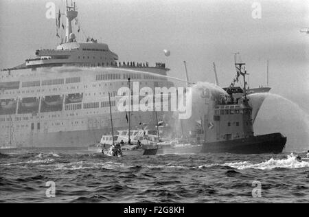 AJAXNETPHOTO. 11TH. JULI 1982. SOUTHAMPTON, ENGLAND. - WAL KEHRT ZURÜCK - S.S.CANBERRA, DIE VON DER MOD ALS ATROOPSHIP WÄHREND DES FALKLANDKONFLIKTS EINGESETZT WURDE, KEHRT NACH SOUTHAMPTON ZURÜCK, BEGLEITET VON EINER RIESIGEN FLOTTE VON BRUNNENFISCHERN. FOTO: JONATHAN EASTLAND/AJAX. REF:820711 3 21A.HD LIN CAN. Stockfoto