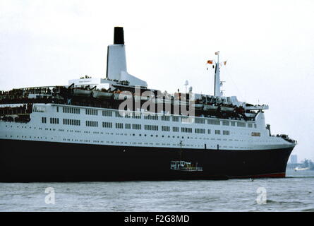 AJAXNETPHOTO. 12. MAI 1982. SOUTHAMPTON, ENGLAND. -TRUPPENTRANSPORTER FÄHRT - DER CUNARD LINER QE2 FÄHRT AM KAI IN SOUTHAMPTON, BELADEN MIT TRUPPEN FÜR DEN FALKLAND-INSELN.  FOTO: JONATHAN EASTLAND/AJAX.  REF: 909612. Stockfoto