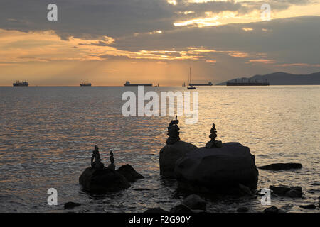 Sonnenuntergang vom Sonnenuntergang Strand English Bay Vancouver zeigen Schiffe am Anker und Nachahmung Inukshuk Stockfoto