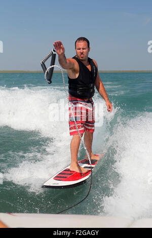 Ein Wakesurfen Mann warf das Abschleppseil zurück zum Boot. Stockfoto