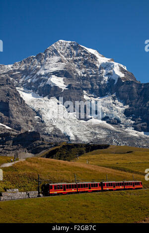 Jungfraubhan trainieren sich nähernden Bahnhof Kleine Scheidegg mit Mönch im Hintergrund der Schweiz Europa Stockfoto