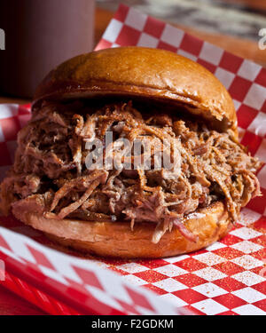 pulled Pork Sandwich auf einem Brötchen auf rote und weiße aufgegebenes Papier Stockfoto