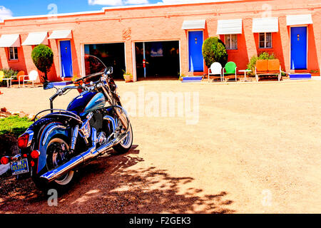 Ein Harley Davidson Motorrad geparkt außerhalb der Gästezimmer im blauen Schwalbe Motel an der Route 66 in Tucumcari, New Mexico Stockfoto