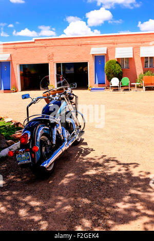 Ein Harley Davidson Motorrad geparkt außerhalb der Gästezimmer im blauen Schwalbe Motel an der Route 66 in Tucumcari, New Mexico Stockfoto