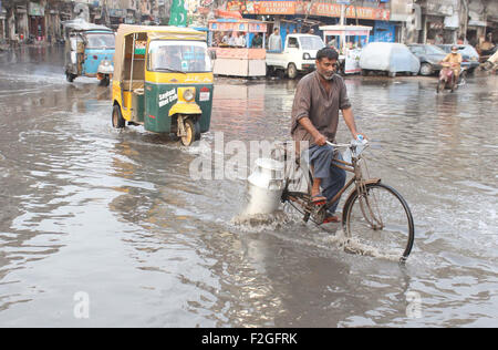 Pendler sind stagnierende Kanalisation Wasser eine unhygienische Atmosphäre schaffen wird, die auf der Durchreise und zeigt die Fahrlässigkeit des KMC, in Pakistan Chowk in Karachi auf Freitag, 18. September 2015. Stockfoto