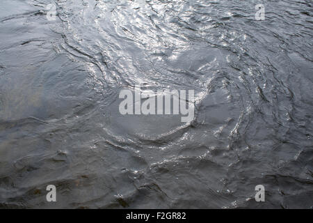 Flusswasser verwirbelt und spiegelt den Himmel. Stockfoto