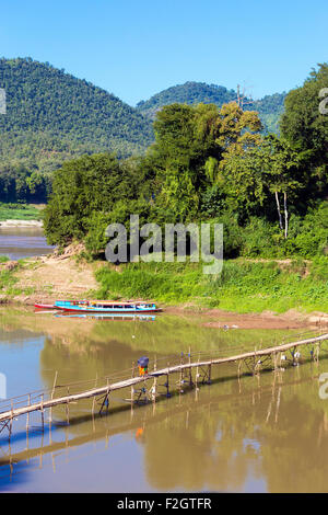 Mönche auf Bambusbrücke über Nam Khan Fluss, Luang Prabang, Laos Stockfoto