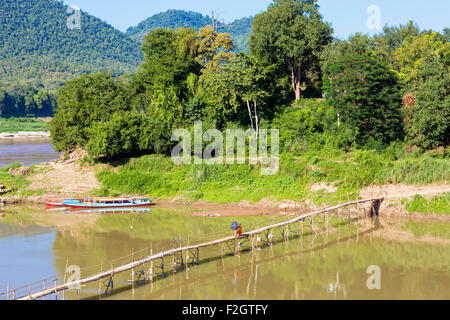 Mönche auf Bambusbrücke über Nam Khan Fluss, Luang Prabang, Laos Stockfoto