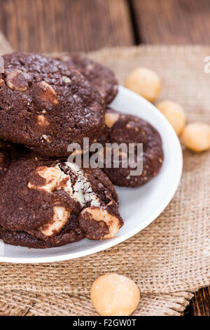 Hausgemachte Schokolade Kekse mit Macadamia-Nüssen (auf hölzernen Hintergrund) Stockfoto
