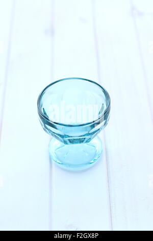Leere blaue Glasschale auf weißem Holz Brett Stockfoto