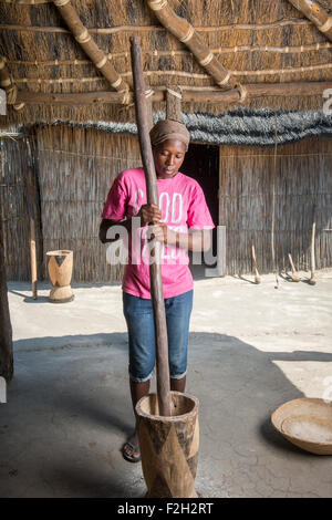 Afrikanerin mit großen Mörser und Stößel in Sexaxa Dorf in Botswana, Afrika Stockfoto