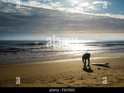Surfer bei Sonnenaufgang am Strand von Seaton Carew dehnen. Nord-Ost-England. Vereinigtes Königreich Stockfoto