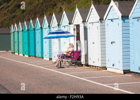 Bournemouth, Dorset, UK 19. September 2015. UK-Wetter: Sonnentag am Strand von Bournemouth zu wärmen, während Besucher für den Strand fahren. Reife Frau im Schatten des Sonnenschirms außerhalb einer Strandhütte auf Promenade zwischen Bournemouth Pier und Boscombe entspannend. Bildnachweis: Carolyn Jenkins/Alamy Live-Nachrichten Stockfoto