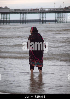 Leute, die Spaß am Rand des Wassers bei Ebbe in Brighton Stockfoto