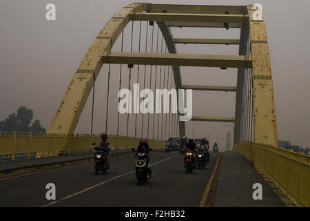 Pekanbaru, der Provinz Riau, Indonesien. 19. September 2015. Auf diesem Foto, aufgenommen am 18. September 2015. Fahrzeuge waren eingehüllt in Nebel, verursacht durch Waldbrände, bei der Überquerung der Brücke Siak III in Pekanbaru, der Provinz Riau, Indonesien. Südostasien hat Nebel umgeben, dass auf dem Bauernhof zerstörten große Teile der Wälder Indonesien während der trockenen Jahreszeit, wodurch Waldbrände, die Verbreitung, Würgen Rauchen und Luftverschmutzung in allen Teilen Indonesiens und den angrenzenden Ländern im Westen. Bildnachweis: Ivan Damanik/Alamy Live-Nachrichten Stockfoto