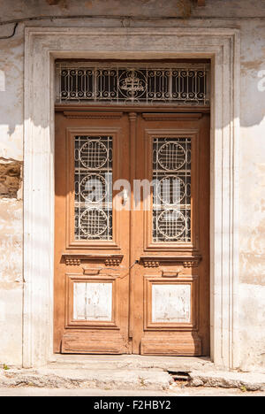 Alte braune Holztür mit weißen Schmiedeeisen Maßwerk Gitter unter Windows. Lefkara. Zypern. Stockfoto