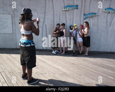 Mädchen-Becher für die Kamera auf Coney Island Boardwalk in Brooklyn, New York. Stockfoto