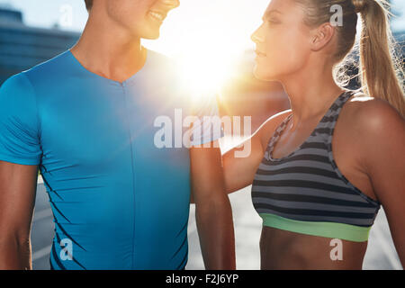 Closeup erschossen zwei junge Athleten stehen am Stadion Rennstrecke an einem sonnigen Tag. Mann und Frau im Sport tragen am athleti Stockfoto
