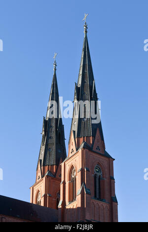 Die zwei Türme, Türme der Kathedrale von Uppsala. Am frühen Morgen beleuchtet und blauen Himmel. Kreuz auf der Spitze. Stockfoto