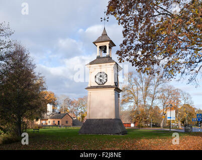 OSTERBYBRUK, SCHWEDEN AM 16. OKTOBER 2013. Blick auf einen hölzernen Glockenturm in der Mitte. Zeichen und Straßen im Hintergrund. Redaktionelle Nutzung Stockfoto