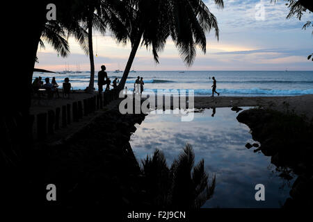 Gruppen von Menschen spazieren am Strand in Playa Tamarindo Guanacaste, Costa Rica in der Dämmerung und Sonnenuntergang. Stockfoto
