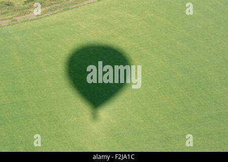 Schatten der Heißluftballon auf Landschaft, Cumbria, England. Stockfoto