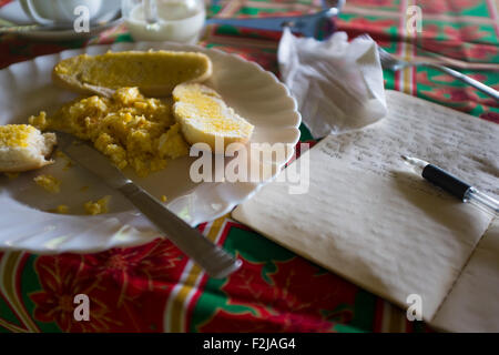 Ein typischer Backpacker Frühstück mit Eiern, Toast, Kaffee und Bio-Honig mit ein tägliches Journal in einer Lodge auf Ometepe, Nicaragua Stockfoto