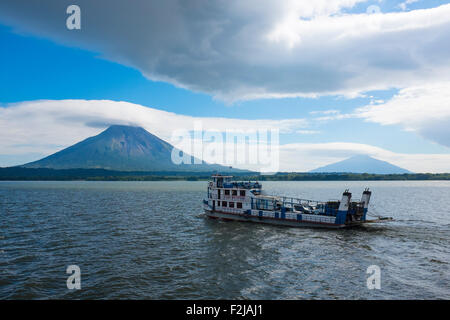 Eine kleines Auto Fähre bringt Menschen und waren auf der Insel Ometepe mit Volcan Concepcion im Hintergrund über Nicaragua-See Stockfoto