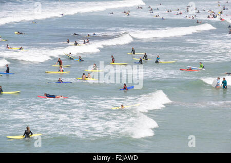 North Cornwall - Polzeath - Surfer Strand - weiße gekrönt Wellenschlag - Surf voller bunter Reiter - jeden Alters - Sonnenlicht Stockfoto