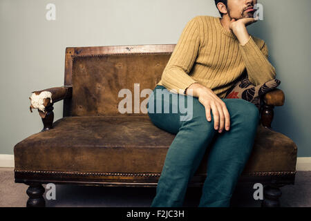 Junger Mann auf sofa Stockfoto