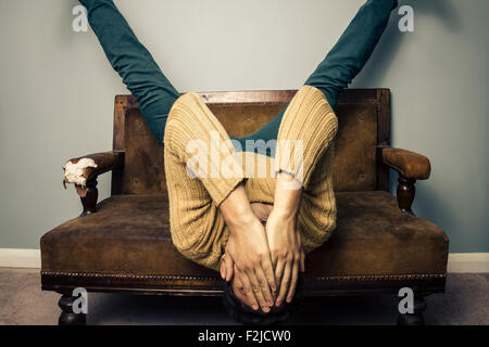 Junger Mann liegend auf dem Kopf nach unten auf dem sofa Stockfoto