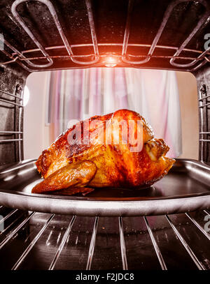 Gebratenes Huhn in den Ofen, Blick aus dem Inneren des Ofens. Kochen in den Ofen. Thanksgiving Day. Stockfoto